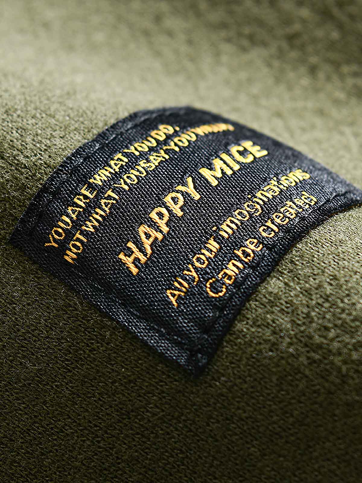 製品画像: フリースタートルネック ミリタリースウェットの全体展示画像。クラシックなタートルネックデザインと3色展開(ミリタリーグリーン、グレー、ブラック)が特徴。WWIIにインスパイアされたミリタリースタイルが際立つ。
詳細画像: 折り返し可能なタートルネック部分と袖まで続くフリース裏地のクローズアップ。防風性と保温性を両立した機能性がわかるディテール。