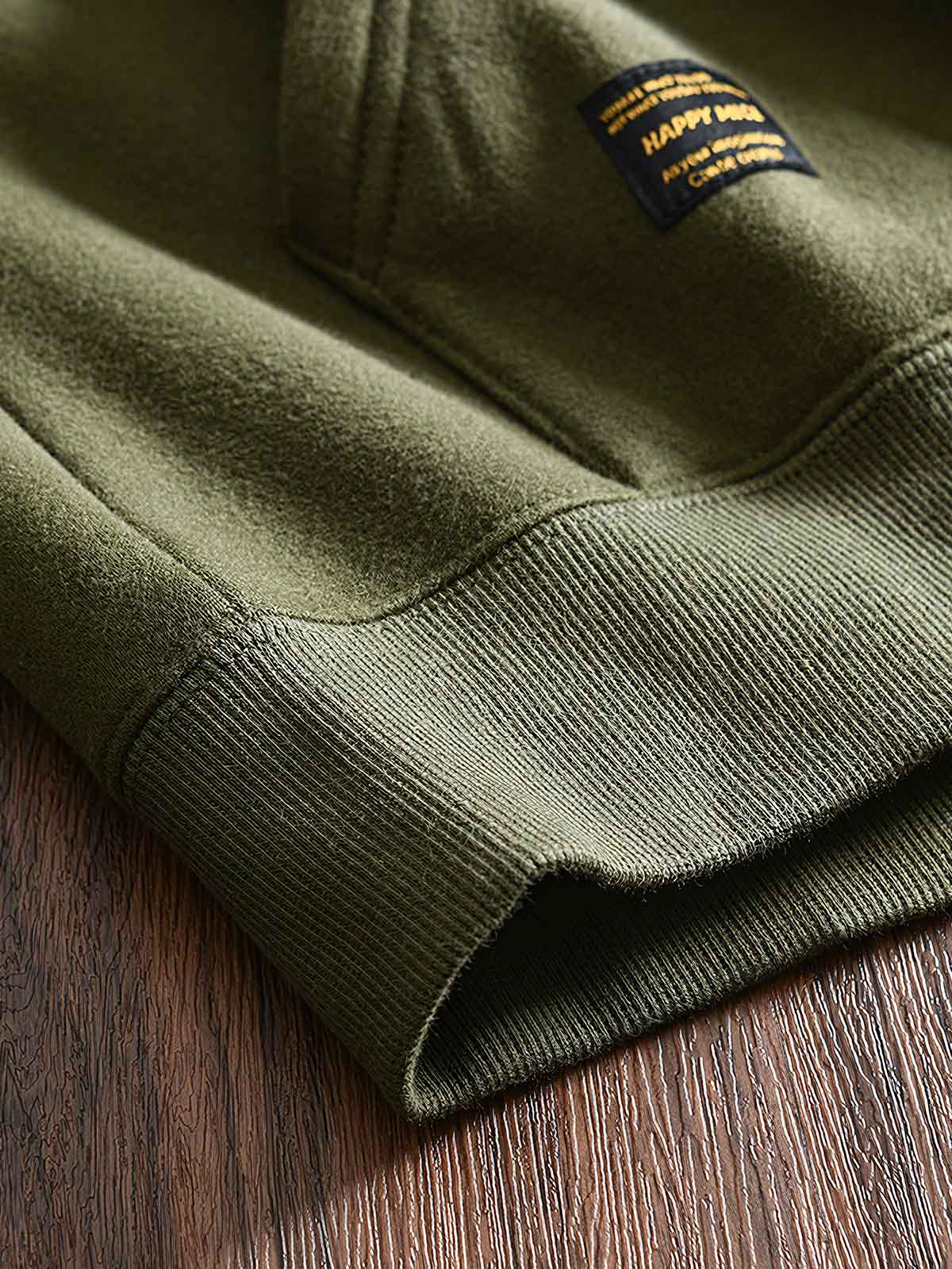 製品画像: フリースタートルネック ミリタリースウェットの全体展示画像。クラシックなタートルネックデザインと3色展開(ミリタリーグリーン、グレー、ブラック)が特徴。WWIIにインスパイアされたミリタリースタイルが際立つ。
詳細画像: 折り返し可能なタートルネック部分と袖まで続くフリース裏地のクローズアップ。防風性と保温性を両立した機能性がわかるディテール。