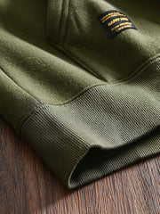 製品画像: フリースタートルネック ミリタリースウェットの全体展示画像。クラシックなタートルネックデザインと3色展開(ミリタリーグリーン、グレー、ブラック)が特徴。WWIIにインスパイアされたミリタリースタイルが際立つ。
詳細画像: 折り返し可能なタートルネック部分と袖まで続くフリース裏地のクローズアップ。防風性と保温性を両立した機能性がわかるディテール。