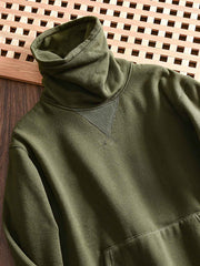 製品画像: フリースタートルネック ミリタリースウェットの全体展示画像。クラシックなタートルネックデザインと3色展開(ミリタリーグリーン、グレー、ブラック)が特徴。WWIIにインスパイアされたミリタリースタイルが際立つ。
詳細画像: 折り返し可能なタートルネック部分と袖まで続くフリース裏地のクローズアップ。防風性と保温性を両立した機能性がわかるディテール。