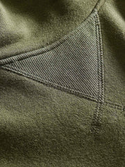 製品画像: フリースタートルネック ミリタリースウェットの全体展示画像。クラシックなタートルネックデザインと3色展開(ミリタリーグリーン、グレー、ブラック)が特徴。WWIIにインスパイアされたミリタリースタイルが際立つ。
詳細画像: 折り返し可能なタートルネック部分と袖まで続くフリース裏地のクローズアップ。防風性と保温性を両立した機能性がわかるディテール。