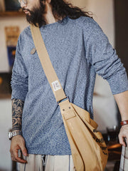 詳細画像: カチオン糸による独特な風合いとヴィンテージ感漂うブラウンのレザーパッチのディテールをクローズアップした画像。見た目の個性と高級感を強調。
モデル画像: 両面フリース起毛 長袖Tシャツを着用したモデルが、リラックスしたカジュアルコーディネートを披露。インナーとしても単独でも活躍するアイテム。