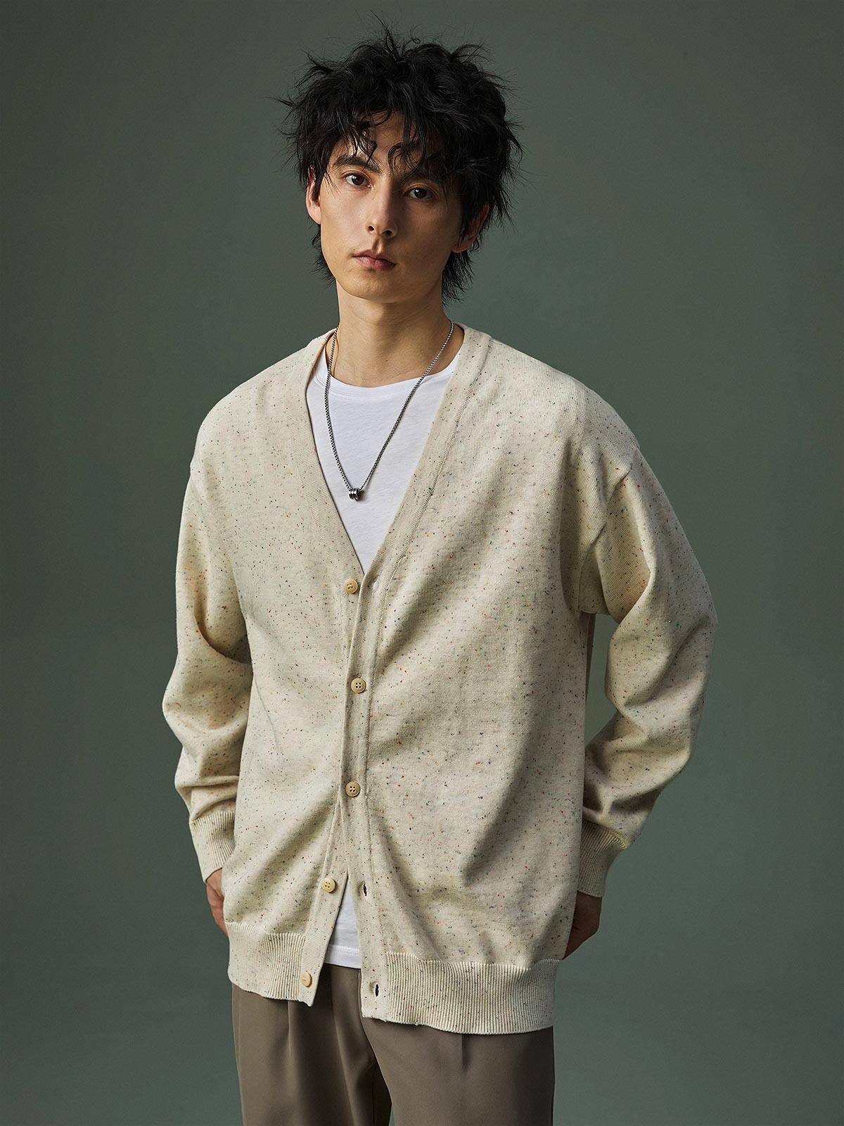 詳細画像
グラデーション樹脂ボタンの高級感あるディテール、精緻なリブ編みの裾と袖口、滑らかな質感を持つ12ゲージ編み地とカラフルドット模様の特写。
モデル画像
モデルがVネック カラフルドット ニット カーディガンを着用し、首元をすっきり見せるシルエットと華やかなドット柄を取り入れた、カジュアルで洗練されたコーディネートを披露。