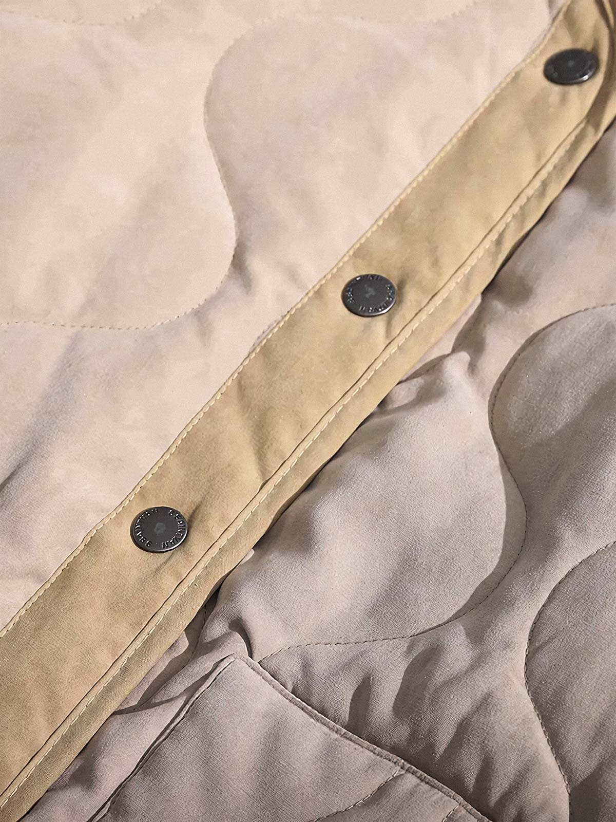 製品画像
ピーチスキン ノーカラー キルティング 中綿ジャケット全体図。滑らかなピーチスキン素材と波形キルティングが特徴の軽量ユニセックスアウター。
詳細画像
柔らかなピーチスキン素材の質感、立体感を生む波形キルティングステッチ、軽量ウォッシュドコットン中綿のディテール特写。