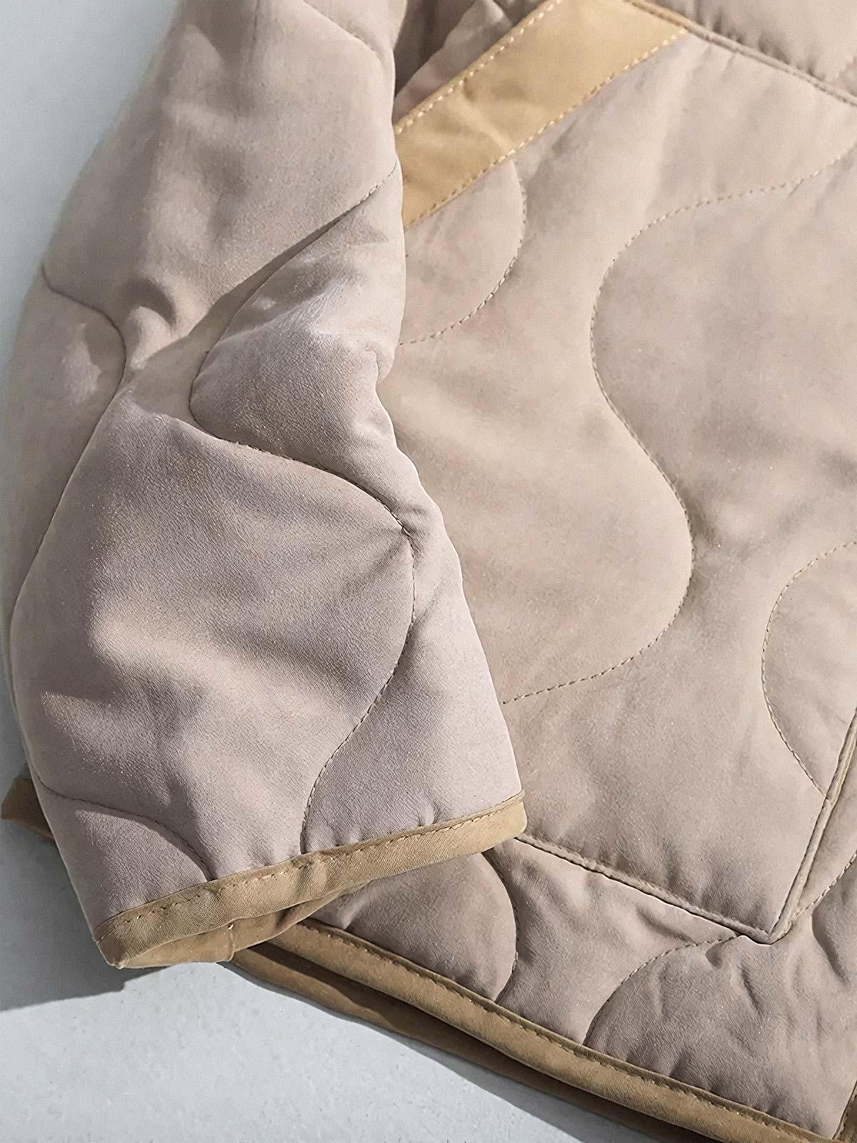 製品画像
ピーチスキン ノーカラー キルティング 中綿ジャケット全体図。滑らかなピーチスキン素材と波形キルティングが特徴の軽量ユニセックスアウター。
詳細画像
柔らかなピーチスキン素材の質感、立体感を生む波形キルティングステッチ、軽量ウォッシュドコットン中綿のディテール特写。