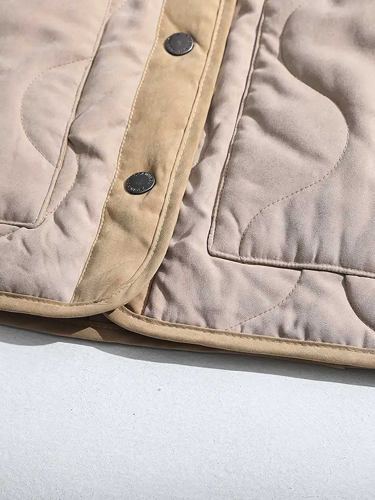 製品画像
ピーチスキン ノーカラー キルティング 中綿ジャケット全体図。滑らかなピーチスキン素材と波形キルティングが特徴の軽量ユニセックスアウター。
詳細画像
柔らかなピーチスキン素材の質感、立体感を生む波形キルティングステッチ、軽量ウォッシュドコットン中綿のディテール特写。