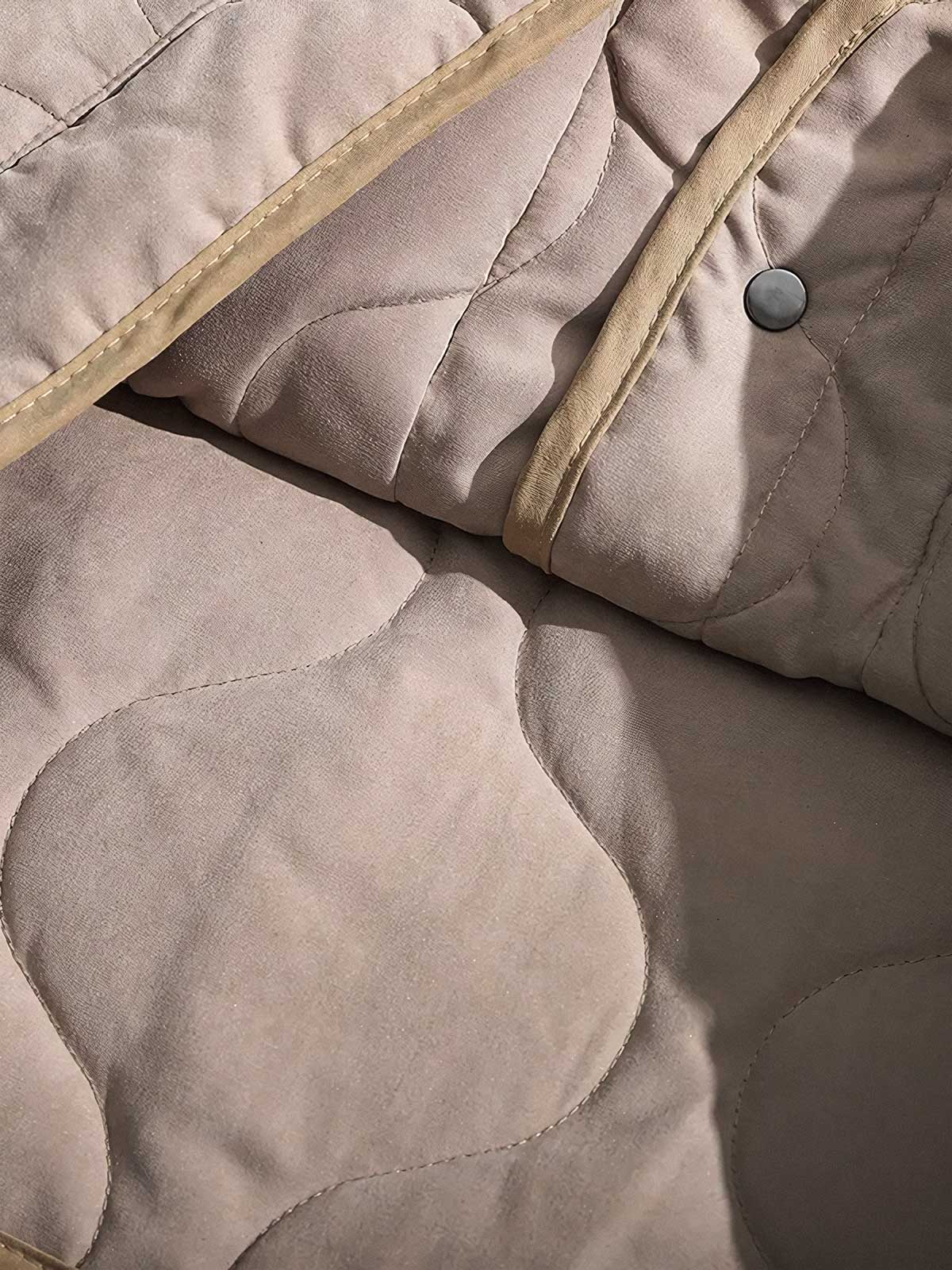 製品画像
ピーチスキン ノーカラー キルティング 中綿ジャケット全体図。滑らかなピーチスキン素材と波形キルティングが特徴の軽量ユニセックスアウター。
詳細画像
柔らかなピーチスキン素材の質感、立体感を生む波形キルティングステッチ、軽量ウォッシュドコットン中綿のディテール特写。