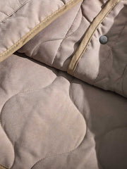 製品画像
ピーチスキン ノーカラー キルティング 中綿ジャケット全体図。滑らかなピーチスキン素材と波形キルティングが特徴の軽量ユニセックスアウター。
詳細画像
柔らかなピーチスキン素材の質感、立体感を生む波形キルティングステッチ、軽量ウォッシュドコットン中綿のディテール特写。