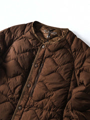 製品画像
ホワイトダックダウン 軽量 ダウンジャケット全体図。シンプルなデザインと700+フィルパワーの高品質ホワイトダックダウンを使用し、軽量で高い保温性を備えた一着。
詳細画像
100%ナイロン素材の防風・撥水性のディテール、高品質90%ホワイトダックダウンとダウン吹き出し防止の縫製、袖口の伸縮仕様の特写。