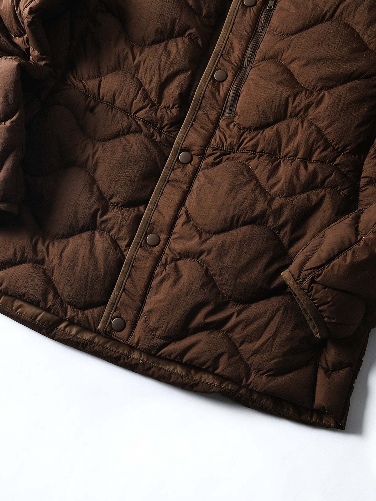 製品画像
ホワイトダックダウン 軽量 ダウンジャケット全体図。シンプルなデザインと700+フィルパワーの高品質ホワイトダックダウンを使用し、軽量で高い保温性を備えた一着。
詳細画像
100%ナイロン素材の防風・撥水性のディテール、高品質90%ホワイトダックダウンとダウン吹き出し防止の縫製、袖口の伸縮仕様の特写。