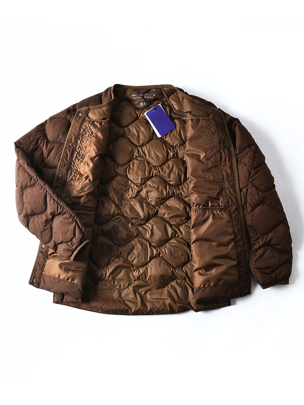 製品画像
ホワイトダックダウン 軽量 ダウンジャケット全体図。シンプルなデザインと700+フィルパワーの高品質ホワイトダックダウンを使用し、軽量で高い保温性を備えた一着。
詳細画像
100%ナイロン素材の防風・撥水性のディテール、高品質90%ホワイトダックダウンとダウン吹き出し防止の縫製、袖口の伸縮仕様の特写。