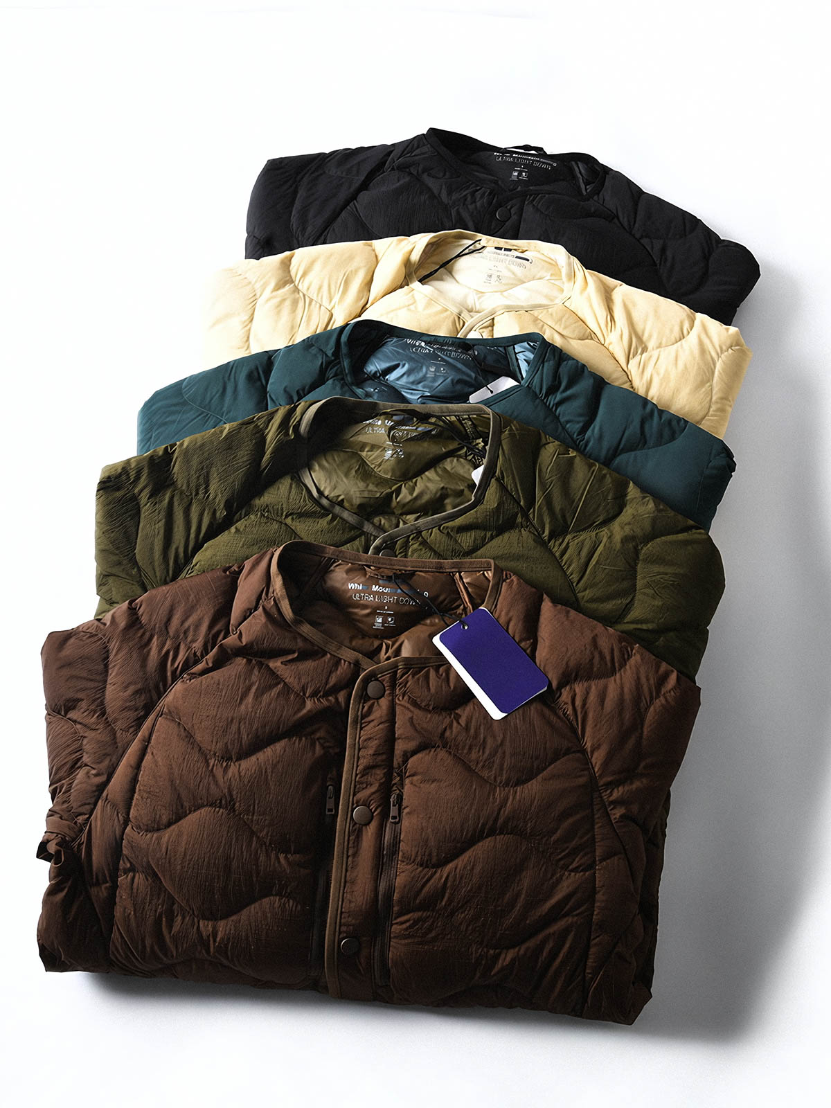 製品画像
ホワイトダックダウン 軽量 ダウンジャケット全体図。シンプルなデザインと700+フィルパワーの高品質ホワイトダックダウンを使用し、軽量で高い保温性を備えた一着。
詳細画像
100%ナイロン素材の防風・撥水性のディテール、高品質90%ホワイトダックダウンとダウン吹き出し防止の縫製、袖口の伸縮仕様の特写。