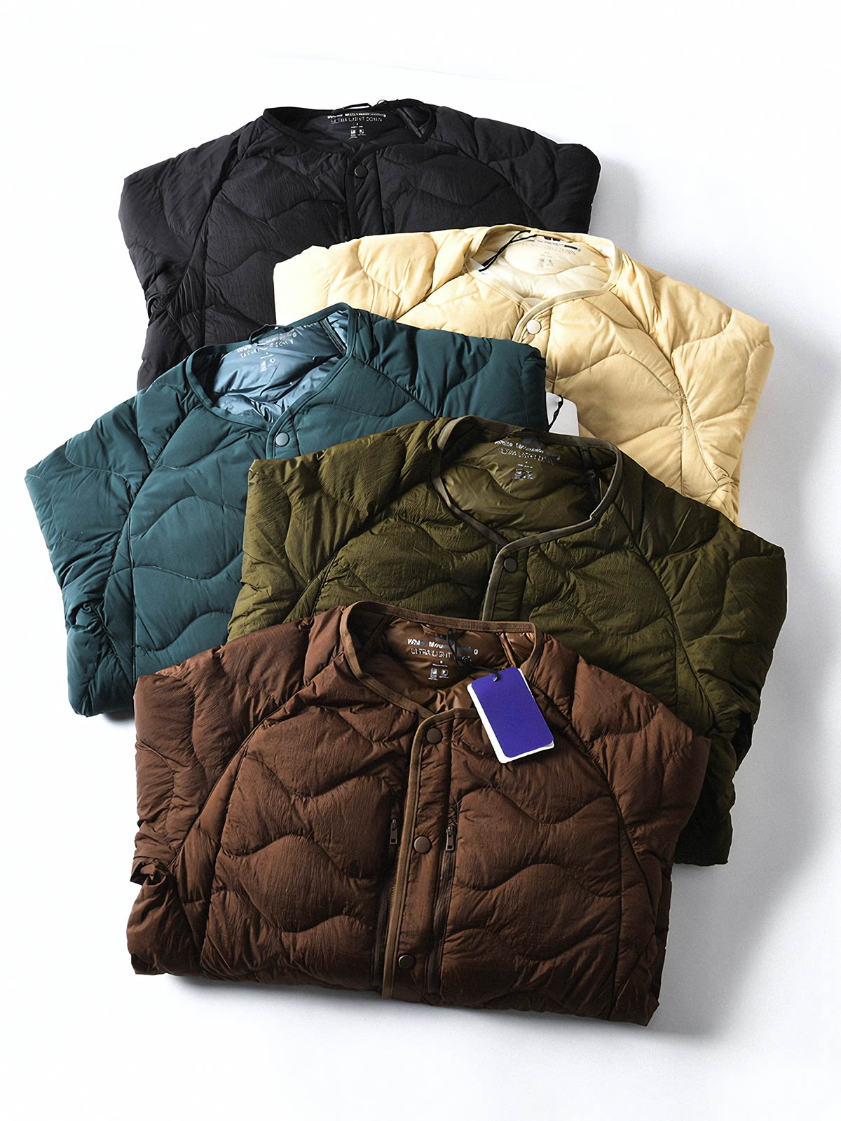 製品画像
ホワイトダックダウン 軽量 ダウンジャケット全体図。シンプルなデザインと700+フィルパワーの高品質ホワイトダックダウンを使用し、軽量で高い保温性を備えた一着。
詳細画像
100%ナイロン素材の防風・撥水性のディテール、高品質90%ホワイトダックダウンとダウン吹き出し防止の縫製、袖口の伸縮仕様の特写。