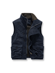 製品画像
N1デッキベスト全体図。シープスキン風ポリエステルファー裏地と100%コットン表地を使用し、耐久性・防風性・保温性を備えたクラシックデザインのベスト。
詳細画像
シープスキン風高密度ポリエステルファーの裏地、冷気を防ぐスタンドカラー、ジッパーとボタンの二重仕様、大容量フラップポケットのディテール特写。