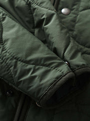 製品画像
「テフロン加工 三防テクノロジー ダイヤキルティング中綿ジャケット全体像。防水、防油、防汚の三防機能と3M™シンサレート中綿が特徴で、軽量で暖かい冬のアウター」
詳細画像
「テフロン加工 ダイヤキルティング中綿ジャケットのダブルジッパーとスナップボタンのディテールクローズアップ。防風性とデザイン性を両立」