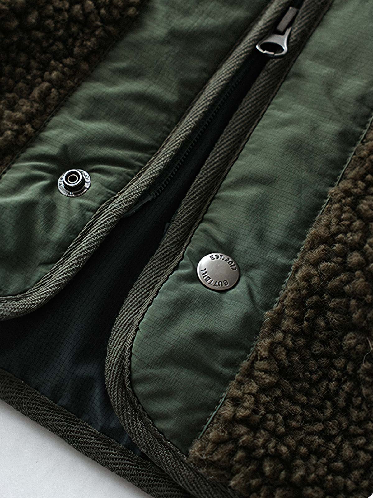 製品画像
「テフロン加工 三防テクノロジー ダイヤキルティング中綿ジャケット全体像。防水、防油、防汚の三防機能と3M™シンサレート中綿が特徴で、軽量で暖かい冬のアウター」
詳細画像
「テフロン加工 ダイヤキルティング中綿ジャケットのダブルジッパーとスナップボタンのディテールクローズアップ。防風性とデザイン性を両立」