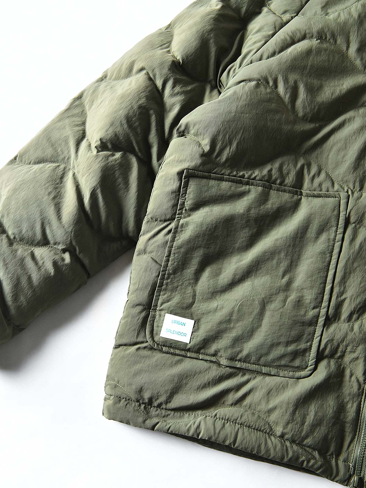 製品画像
「4色展開の防風防水中綿ジャケット。アウトドア素材とポリエステル中綿を採用し、軽量設計で保温性と高機能性を兼ね備えた全体写真。」
詳細画像
「防風性に優れたアウトドア素材の質感と軽量化された中空構造ポリエステル繊維を使用した中綿ディテール。多機能ポケットの実用性も際立つ中綿ジャケット詳細写真。」