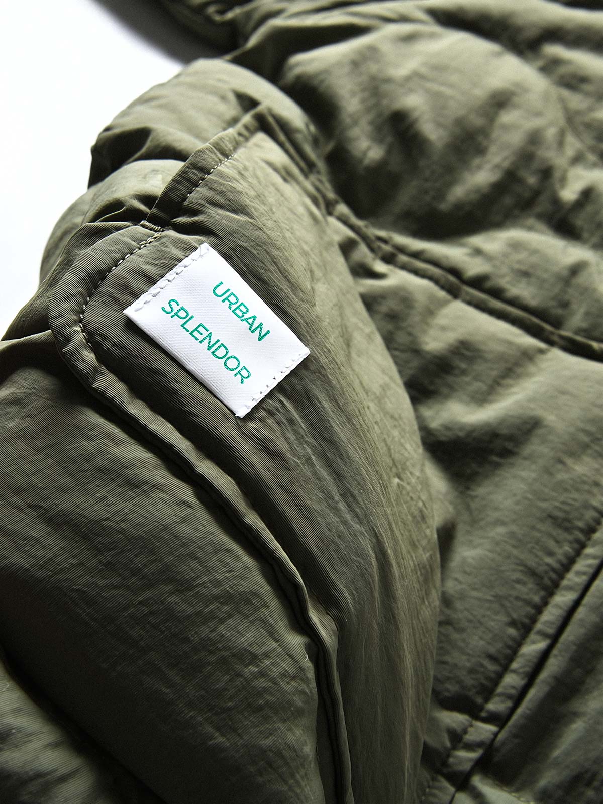 製品画像
「4色展開の防風防水中綿ジャケット。アウトドア素材とポリエステル中綿を採用し、軽量設計で保温性と高機能性を兼ね備えた全体写真。」
詳細画像
「防風性に優れたアウトドア素材の質感と軽量化された中空構造ポリエステル繊維を使用した中綿ディテール。多機能ポケットの実用性も際立つ中綿ジャケット詳細写真。」