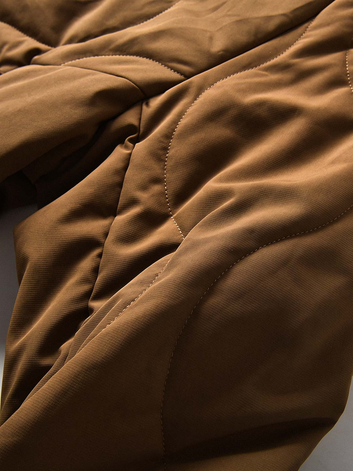 製品画像
「波形キルティングデザインとハイネック仕様が特徴の保温ダウンジャケット正面写真。防風性・保温性・快適性に優れ、静電気防止加工を施したナイロン素材を採用した秋冬に最適なアイテム。」
詳細画像
「フラップ付きの両サイドポケットと背面の通気性メッシュパネルのディテール写真。波形キルティングで中綿が均等に保温性を発揮し、エアダウン素材が快適さを提供するジャケットの特徴を強調した画像。」