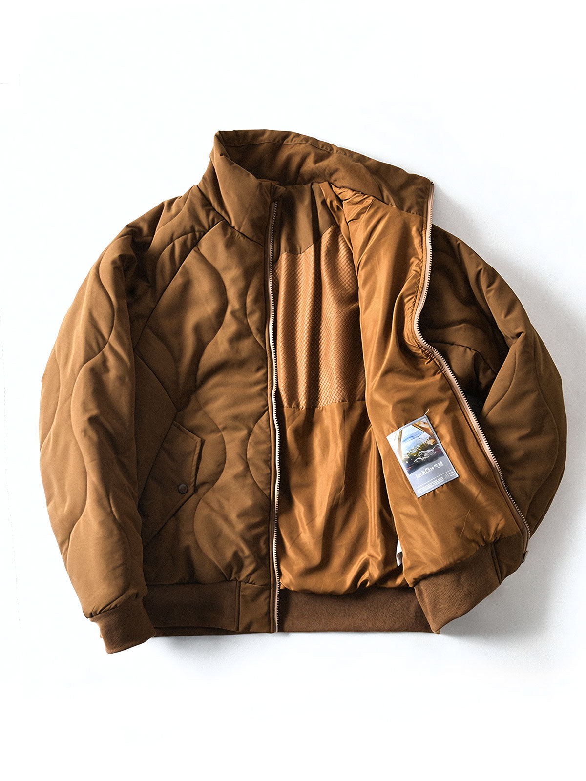 製品画像
「波形キルティングデザインとハイネック仕様が特徴の保温ダウンジャケット正面写真。防風性・保温性・快適性に優れ、静電気防止加工を施したナイロン素材を採用した秋冬に最適なアイテム。」
詳細画像
「フラップ付きの両サイドポケットと背面の通気性メッシュパネルのディテール写真。波形キルティングで中綿が均等に保温性を発揮し、エアダウン素材が快適さを提供するジャケットの特徴を強調した画像。」