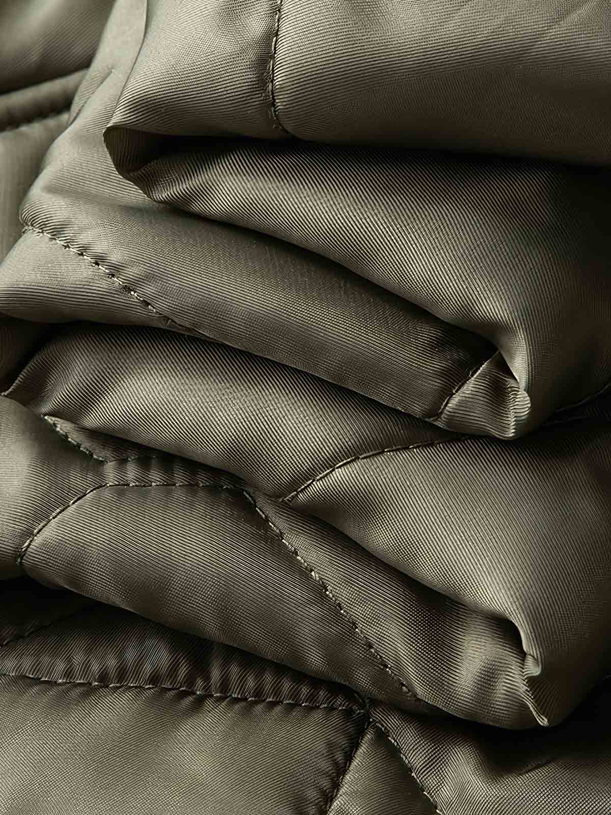 製品画像
「ヴィンテージ感漂うアメリカンミリタリースタイルのM65ライナー CWU-9P 中綿ジャケット全体展示写真。ダイヤモンドキルティングデザインとリブ仕様を備えた軽量で保温性に優れた一着。」
詳細画像
「ダイヤモンドキルティングデザインが施された生地のディテール写真と、防風性能を高めるリブ仕様の袖口のクローズアップ写真。」