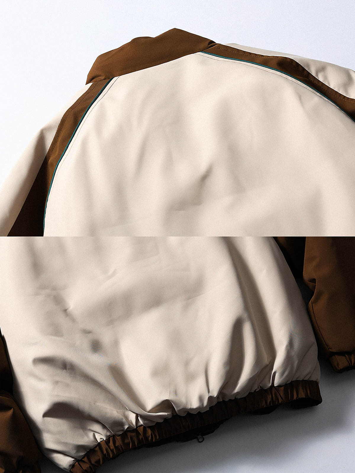 製品画像
「目を引くバイカラーとアーチ型切り替えデザインを特徴としたスタンドカラー中綿ジャケット。防風性と保温性に優れ、冬のアウトドアや日常使いに最適なスポーティなルーズフィットジャケットの全体図」
詳細画像
「バイカラーのアーチパターン切り替えデザインとジッパー付きスタンドカラーが特徴の中綿ジャケット。防風性と耐久性を兼ね備えたディテールのクローズアップ」