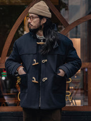 詳細画像
WWI時代のデザインを反映した木製トグルボタンと取り外し可能なストームフラップのディテール。160gウォッシャブルコットン中綿が暖かさと快適さを提供。
モデル画像
モデルがウール混ロング丈フード付きダッフルコートを着用し、冬のヴィンテージ通勤スタイルを演出。クラシックなデザインと現代的な機能性を融合した冬の必須アイテム。