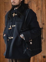 詳細画像
WWI時代のデザインを反映した木製トグルボタンと取り外し可能なストームフラップのディテール。160gウォッシャブルコットン中綿が暖かさと快適さを提供。
モデル画像
モデルがウール混ロング丈フード付きダッフルコートを着用し、冬のヴィンテージ通勤スタイルを演出。クラシックなデザインと現代的な機能性を融合した冬の必須アイテム。