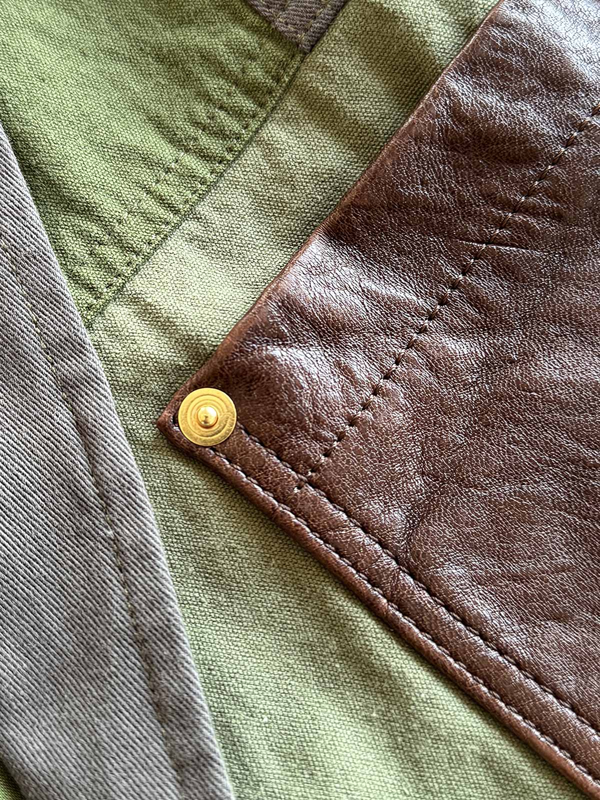 製品画像
パッチワーク ホースハイド ハンティングジャケットの正面全体イメージ。伝統的なパッチワークデザインと高級感あるホースハイドポケットが特徴的で、ヴィンテージ感漂う一着。
詳細画像
ホースハイドポケットと純銅リベットのディテール。ウォッシュ加工仕上げの100%コットン素材が耐久性と快適さを提供。