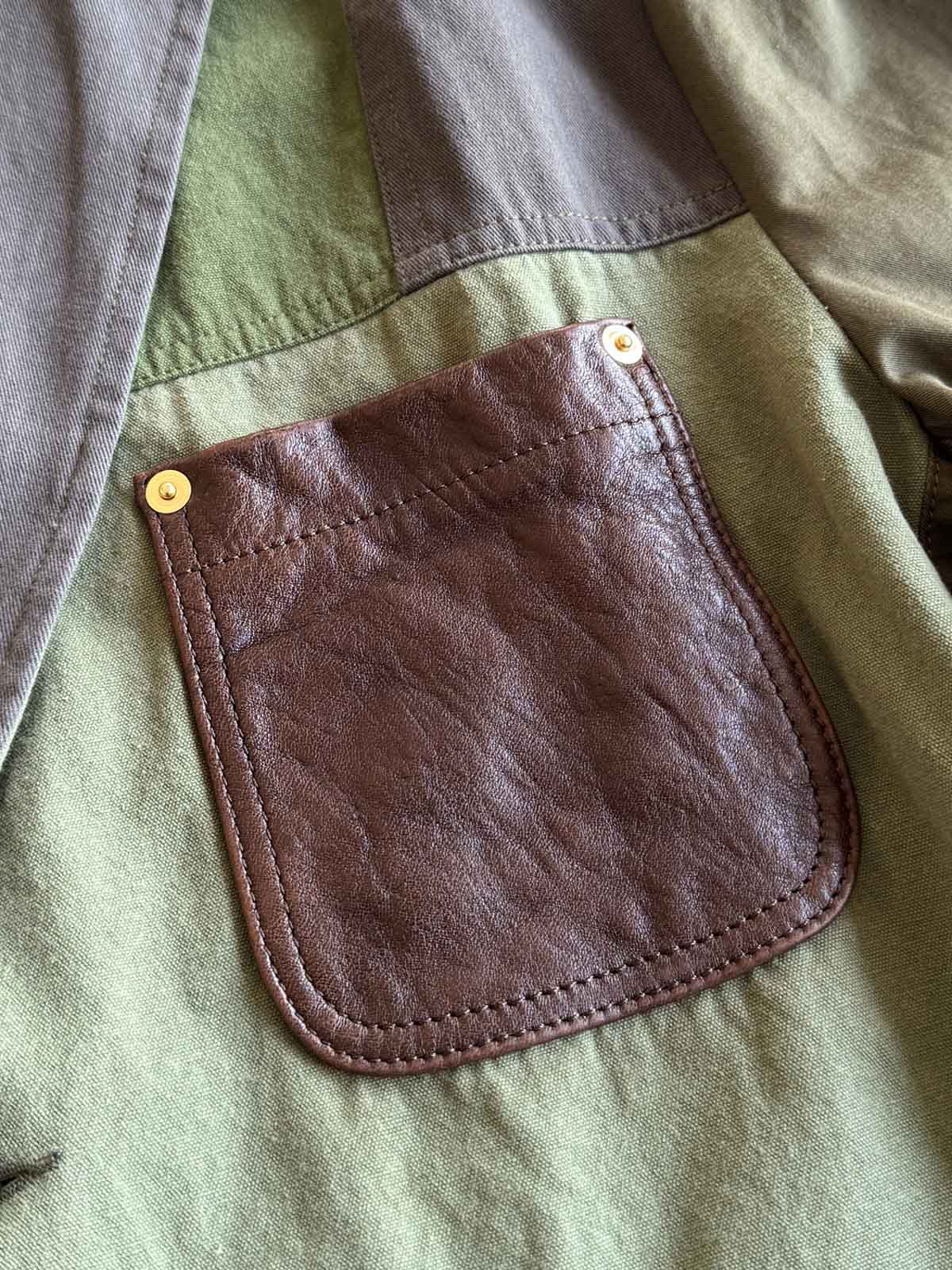 製品画像
パッチワーク ホースハイド ハンティングジャケットの正面全体イメージ。伝統的なパッチワークデザインと高級感あるホースハイドポケットが特徴的で、ヴィンテージ感漂う一着。
詳細画像
ホースハイドポケットと純銅リベットのディテール。ウォッシュ加工仕上げの100%コットン素材が耐久性と快適さを提供。