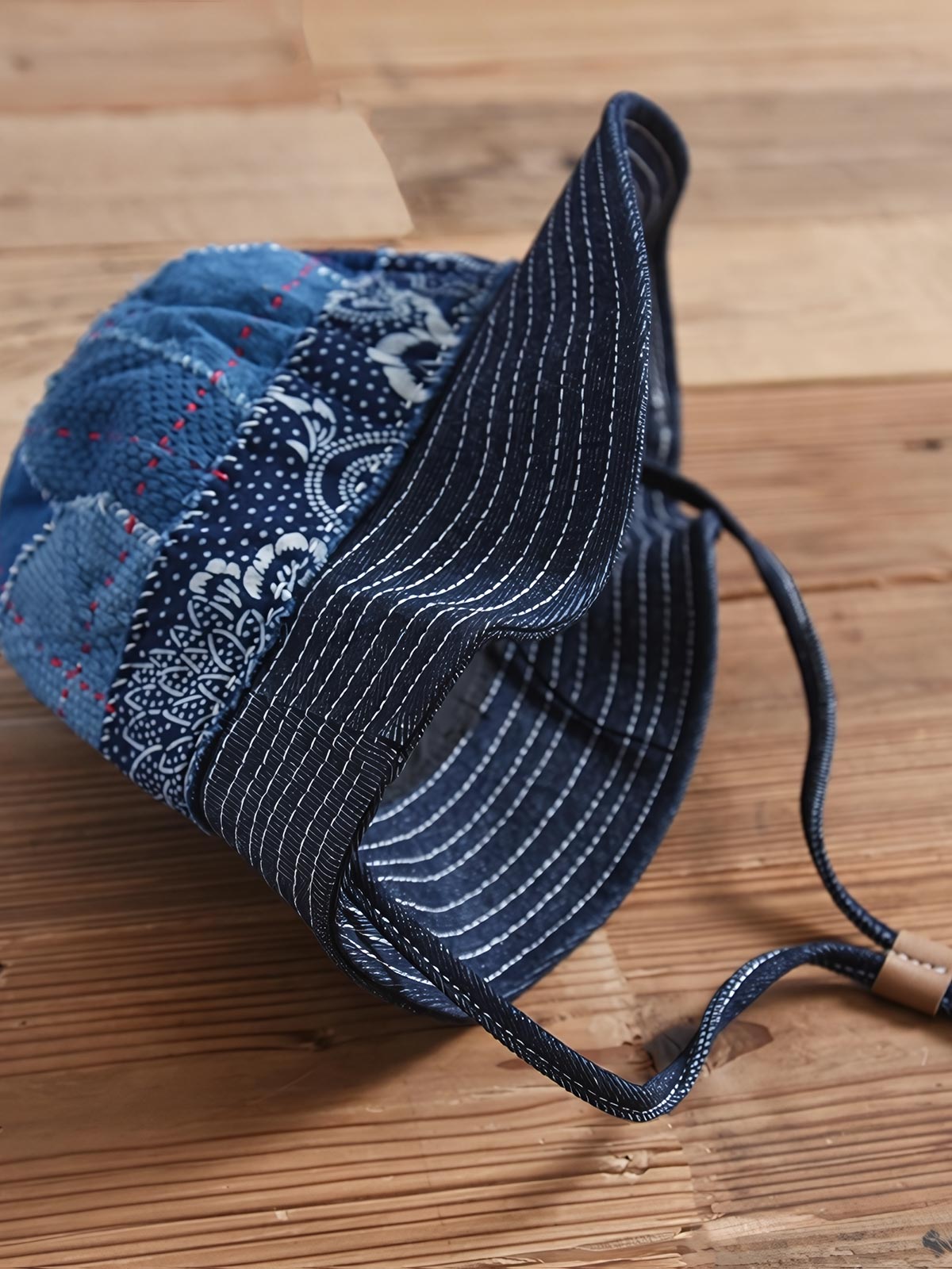 製品画像: ハンドメイド 古布パッチワーク 藍染め 剣道着生地 バケットハット。藍染めと剣道着生地を組み合わせた一点物のバケットハットの全体展示図。
詳細画像: 丁寧なパッチワークディテールと、剣道着生地の風合いを引き立てる細かなステッチのクローズアップ。