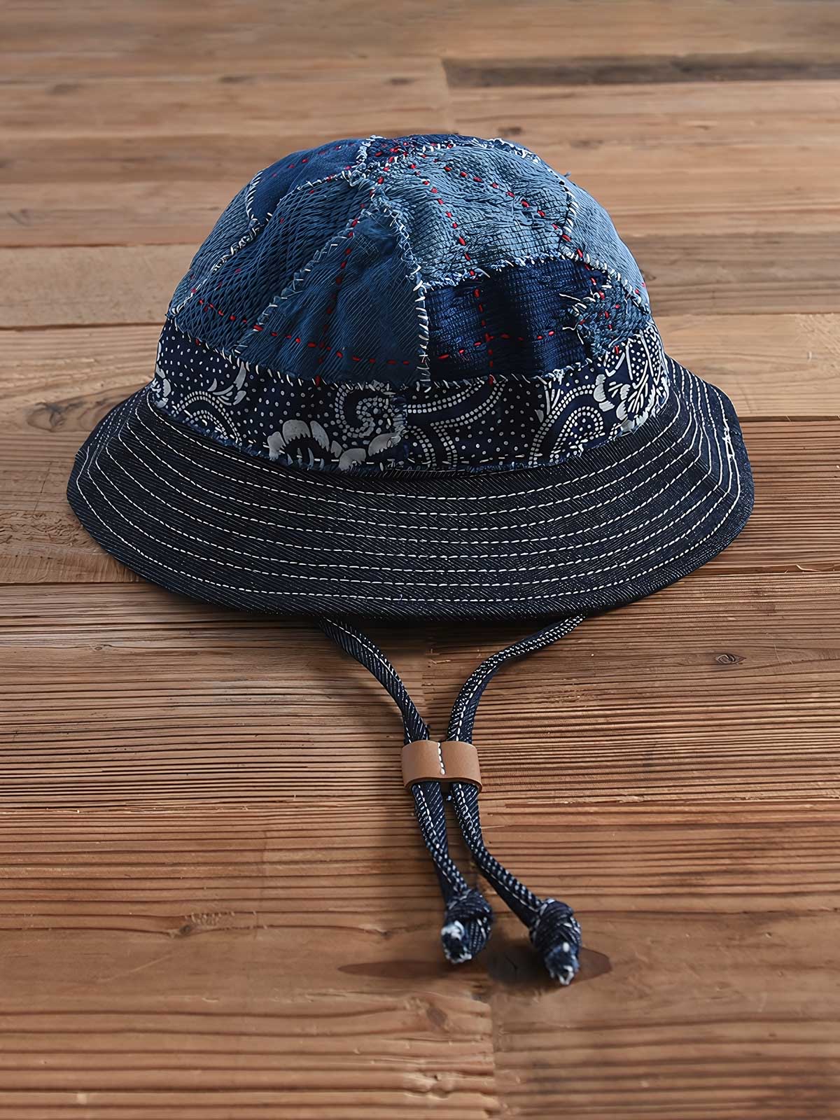 製品画像: ハンドメイド 古布パッチワーク 藍染め 剣道着生地 バケットハット。藍染めと剣道着生地を組み合わせた一点物のバケットハットの全体展示図。
詳細画像: 丁寧なパッチワークディテールと、剣道着生地の風合いを引き立てる細かなステッチのクローズアップ。