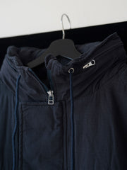 詳細画像
「ペイズリー柄の裏地と日本製YKK製の両開きファスナーのディテールを特写した画像。ヴィンテージデザインと高機能性を兼ね備えたジャケット。」
モデル画像
「モデルがトーンオントーン パッチワーク ミドル丈中綿ジャケットを着用し、デニムパンツと合わせた冬のアウトドアカジュアルスタイルを披露。」