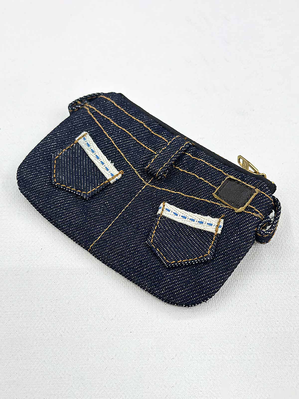 製品画像
「デニム生地を使用したジーンズ型デザインのカードケース全体展示図。二本針ステッチや銅製リベット、バックポケットの刺繍飾りが特徴的なヴィンテージ風デザイン。」
詳細画像
「デニム カードケースのディテール特写。二本針ステッチ、銅製リベット、刺繍入りバックポケットなど、ジーンズを彷彿とさせる精巧なデザインが際立つ。」