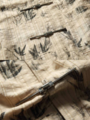 水墨画技法で精密に描かれたグレースケールの竹林プリントのクローズアップ。伝統的な美しさと現代的なシャツデザインが融合され、シンプルなボタンと襟元がシャツのモダンさと実用性を強調しています。