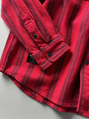 製品画像
「ヘビーフランネル素材を使用したストライプ長袖シャツ全体展示図。ウォッシュ加工によりヴィンテージ感が漂い、クラシックなアメリカンカジュアルスタイルを再現。」
詳細画像
「フランネル素材のテクスチャーと金属ボタンのディテール特写。ウォッシュ加工による自然な風合いと、実用的でデザイン性のある金属ボタンが魅力。」