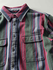 製品画像
「ヘビーフランネル素材を使用したストライプ長袖シャツ全体展示図。ウォッシュ加工によりヴィンテージ感が漂い、クラシックなアメリカンカジュアルスタイルを再現。」
詳細画像
「フランネル素材のテクスチャーと金属ボタンのディテール特写。ウォッシュ加工による自然な風合いと、実用的でデザイン性のある金属ボタンが魅力。」