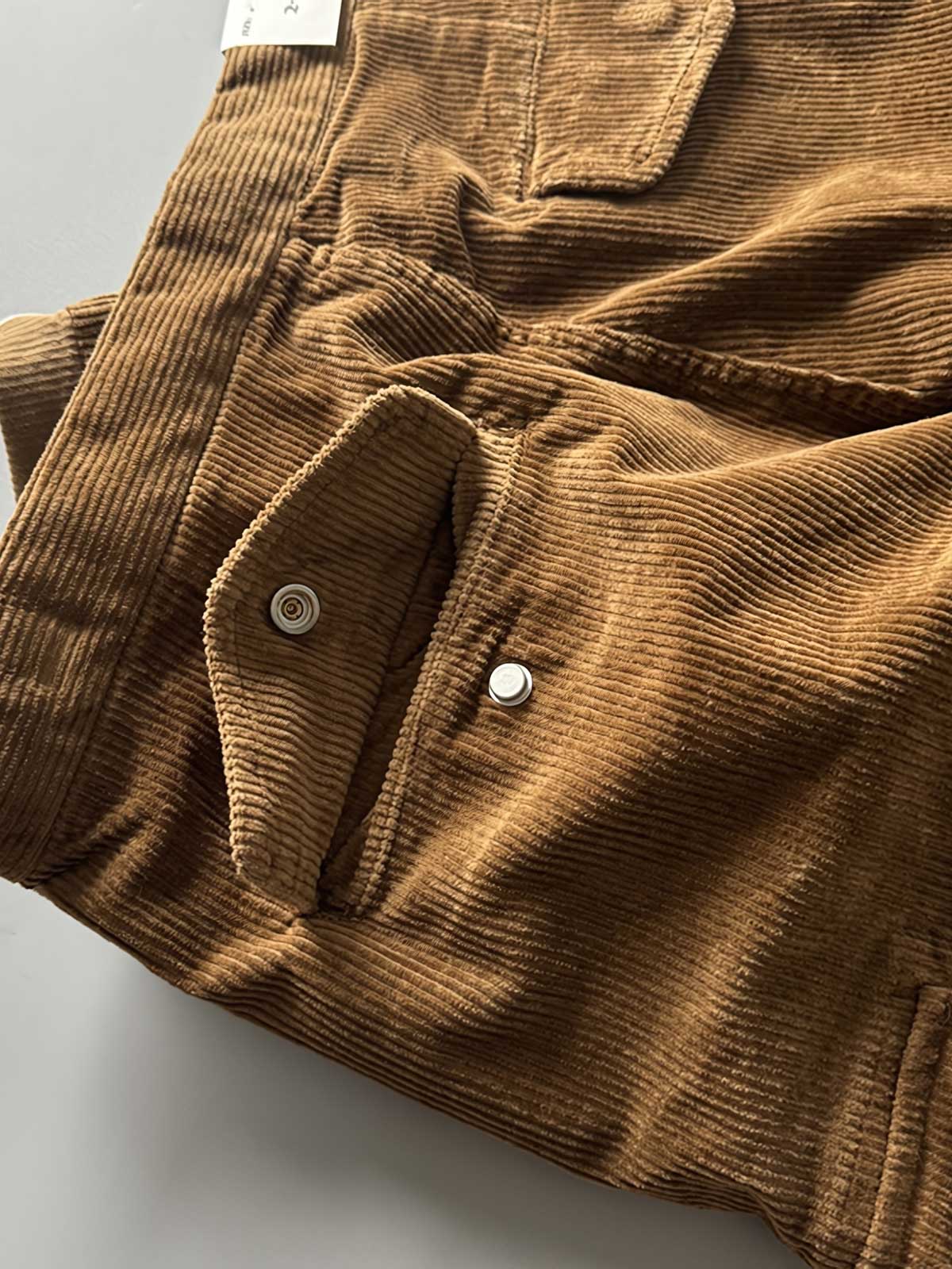 製品画像
「重厚なコーデュロイ素材を使用したカーゴパンツの全体展示図。クラシックなヴィンテージスタイルと快適な履き心地を兼ね備え、テーパードシルエットが脚のラインを美しく見せるデザイン。」
詳細画像
「カーゴパンツの斜め立体ポケットのディテール特写。収納性を高めるだけでなく、全体にカーゴスタイルの立体感を加えたデザイン。」