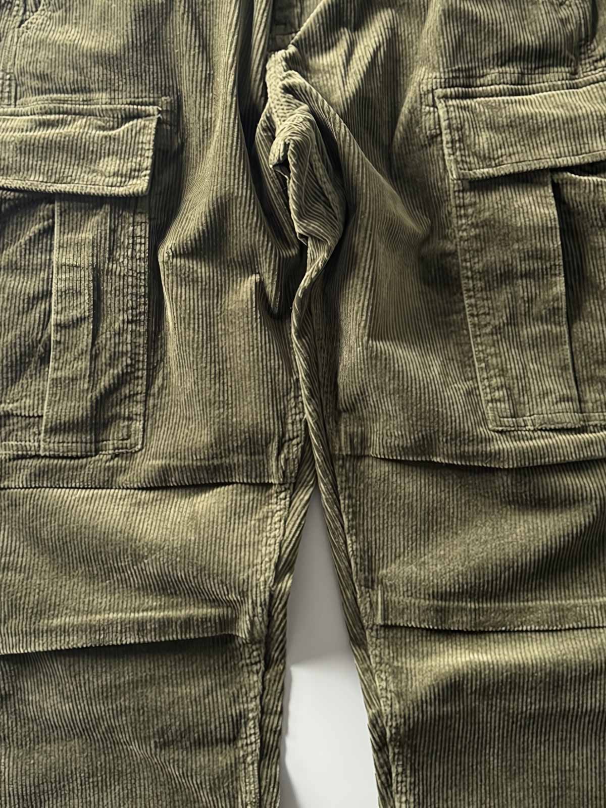 製品画像
「重厚なコーデュロイ素材を使用したカーゴパンツの全体展示図。クラシックなヴィンテージスタイルと快適な履き心地を兼ね備え、テーパードシルエットが脚のラインを美しく見せるデザイン。」
詳細画像
「カーゴパンツの斜め立体ポケットのディテール特写。収納性を高めるだけでなく、全体にカーゴスタイルの立体感を加えたデザイン。」