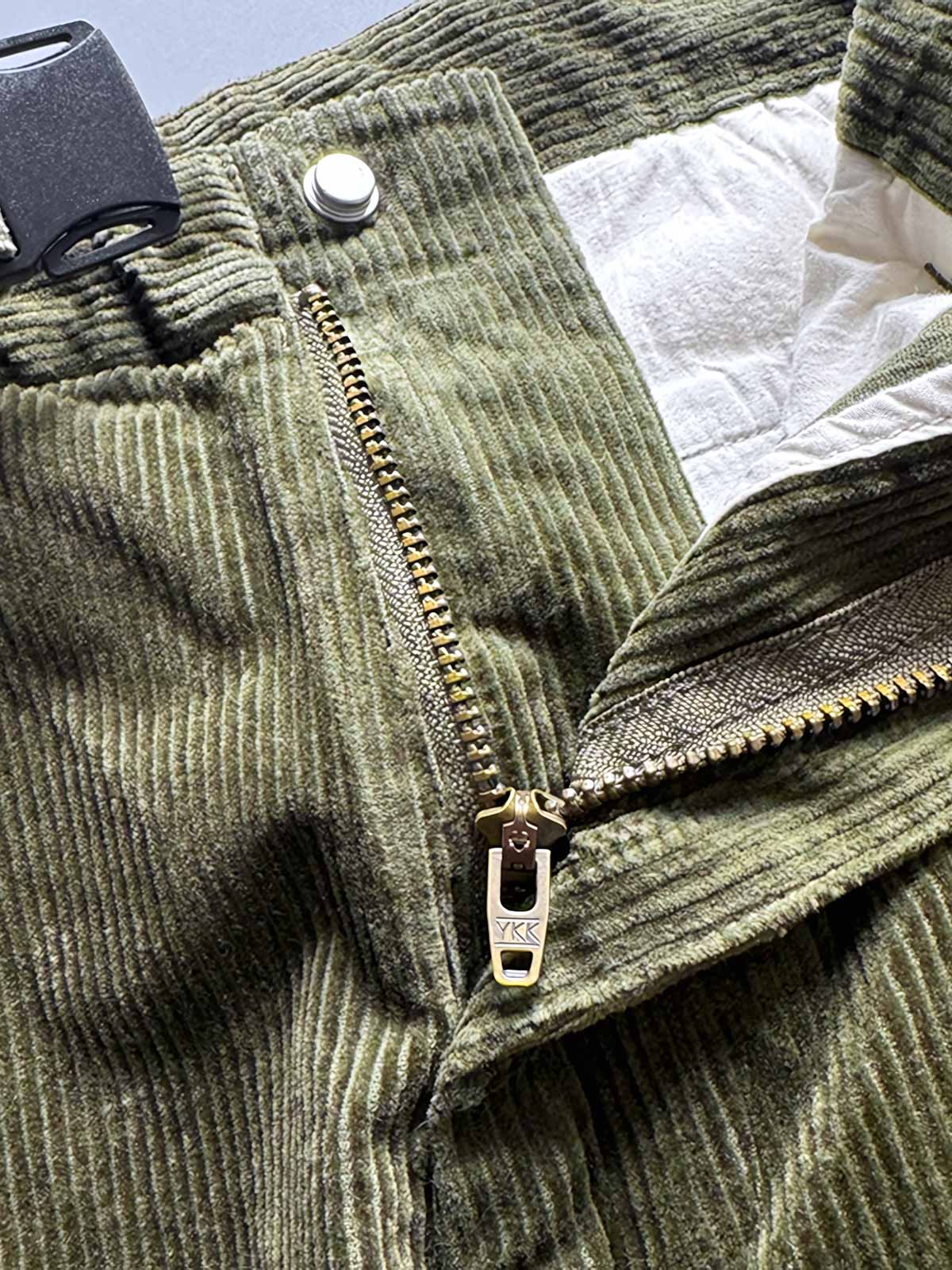 製品画像
「重厚なコーデュロイ素材を使用したカーゴパンツの全体展示図。クラシックなヴィンテージスタイルと快適な履き心地を兼ね備え、テーパードシルエットが脚のラインを美しく見せるデザイン。」
詳細画像
「カーゴパンツの斜め立体ポケットのディテール特写。収納性を高めるだけでなく、全体にカーゴスタイルの立体感を加えたデザイン。」