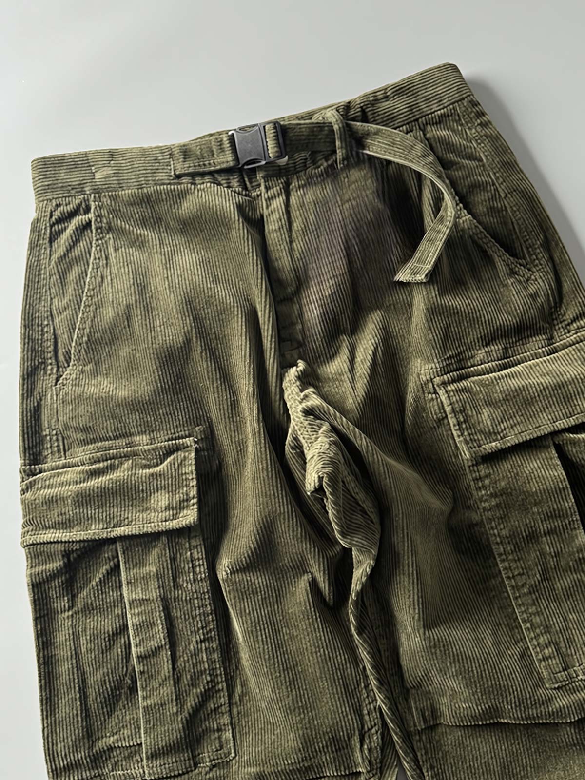 製品画像
「重厚なコーデュロイ素材を使用したカーゴパンツの全体展示図。クラシックなヴィンテージスタイルと快適な履き心地を兼ね備え、テーパードシルエットが脚のラインを美しく見せるデザイン。」
詳細画像
「カーゴパンツの斜め立体ポケットのディテール特写。収納性を高めるだけでなく、全体にカーゴスタイルの立体感を加えたデザイン。」