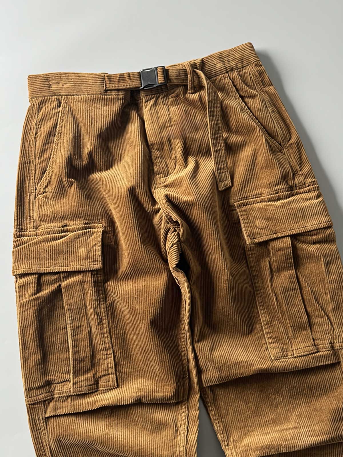 製品画像
「重厚なコーデュロイ素材を使用したカーゴパンツの全体展示図。クラシックなヴィンテージスタイルと快適な履き心地を兼ね備え、テーパードシルエットが脚のラインを美しく見せるデザイン。」
詳細画像
「カーゴパンツの斜め立体ポケットのディテール特写。収納性を高めるだけでなく、全体にカーゴスタイルの立体感を加えたデザイン。」