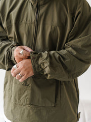 詳細画像
胸元や肩部分に施された立体的なラインデザイン、繊細なグリッド模様、そしてYKK製のマット仕上げファスナーを搭載したポケットの特写。機能性とデザイン性を両立したミリタリースタイルが際立つディテール。
モデル画像
オーバーサイズのシルエットでレイヤードスタイルを楽しめる、多ポケットジャケットを着用したモデルのアウトドアコーディネート。タウンユースやキャンプシーンでの汎用性の高さが映えるスタイル。