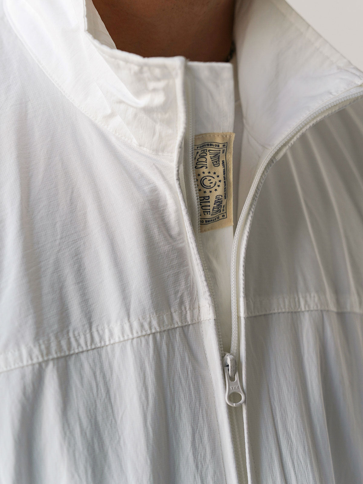 詳細画像
胸元や肩部分に施された立体的なラインデザイン、繊細なグリッド模様、そしてYKK製のマット仕上げファスナーを搭載したポケットの特写。機能性とデザイン性を両立したミリタリースタイルが際立つディテール。
モデル画像
オーバーサイズのシルエットでレイヤードスタイルを楽しめる、多ポケットジャケットを着用したモデルのアウトドアコーディネート。タウンユースやキャンプシーンでの汎用性の高さが映えるスタイル。