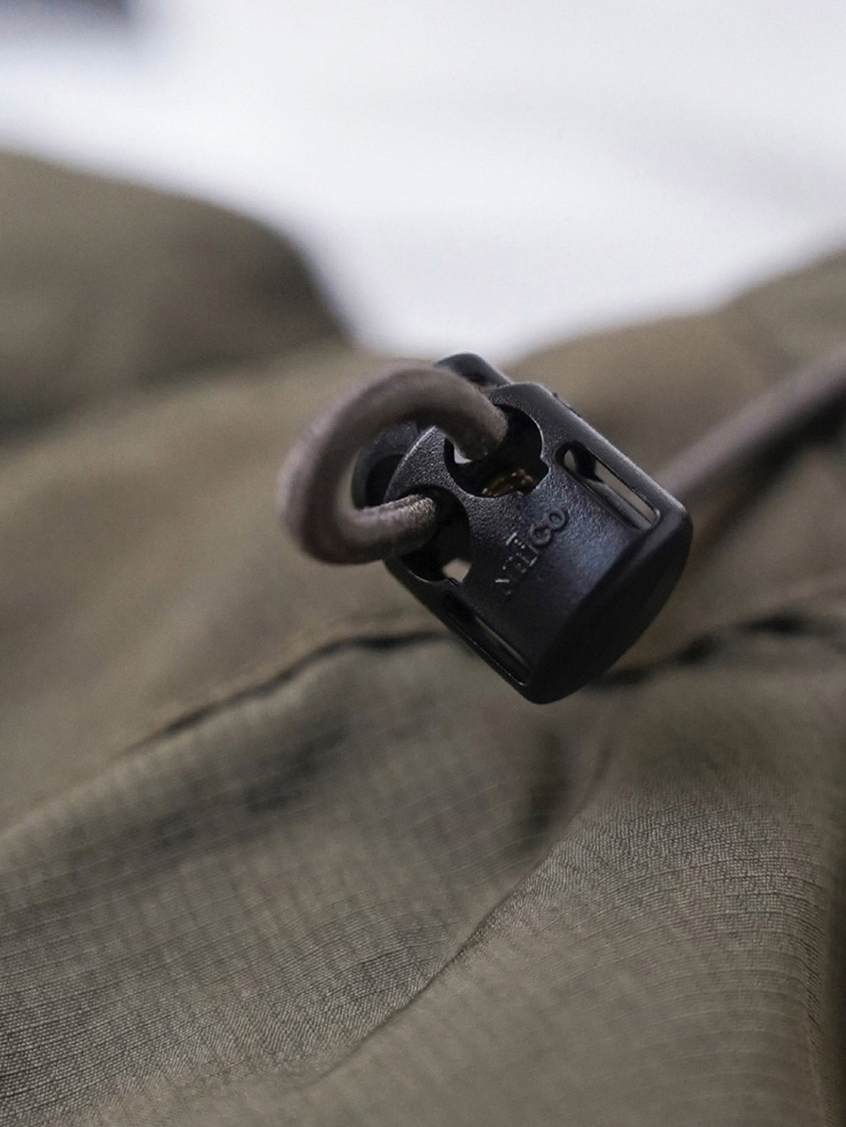 製品画像
軽量で耐久性に優れたナイロンとポリエステルの混紡素材を使用した、多ポケットハーフジップジャケットの全体展示。ヴィンテージ感あふれるデザインと実用的な収納性を備え、アウトドアや日常使いに最適なスタイリッシュなアイテム。
詳細画像
胸元や肩部分に施された立体的なラインデザイン、繊細なグリッド模様、そしてYKK製のマット仕上げファスナーを搭載したポケットの特写。機能性とデザイン性を両立したミリタリースタイルが際立つディテール。