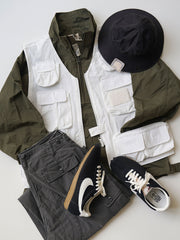 製品画像
軽量で耐久性に優れたナイロンとポリエステルの混紡素材を使用した、多ポケットハーフジップジャケットの全体展示。ヴィンテージ感あふれるデザインと実用的な収納性を備え、アウトドアや日常使いに最適なスタイリッシュなアイテム。
詳細画像
胸元や肩部分に施された立体的なラインデザイン、繊細なグリッド模様、そしてYKK製のマット仕上げファスナーを搭載したポケットの特写。機能性とデザイン性を両立したミリタリースタイルが際立つディテール。