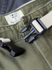 製品画像
ヴィンテージ感漂うバティック染めが特徴の多ポケットロングパンツ全体画像。ミリタリーテイストを取り入れ、300gのコットンサテン生地で耐久性と実用性を兼ね備えたデザイン。
詳細画像
バティック染めによる独特なテクスチャーや、取り外し可能なナイロンベルト、UTX Duraflexバックル、そして膝部分の補強パッチとYKK製カスタムジッパーのディテールショット。高い機能性が際立つ細部。