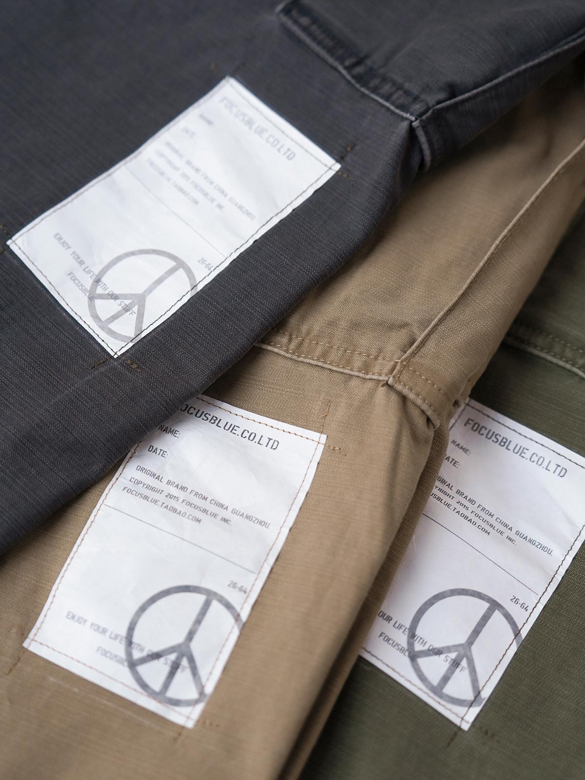 製品画像
ヴィンテージ感漂うバティック染めが特徴の多ポケットロングパンツ全体画像。ミリタリーテイストを取り入れ、300gのコットンサテン生地で耐久性と実用性を兼ね備えたデザイン。
詳細画像
バティック染めによる独特なテクスチャーや、取り外し可能なナイロンベルト、UTX Duraflexバックル、そして膝部分の補強パッチとYKK製カスタムジッパーのディテールショット。高い機能性が際立つ細部。