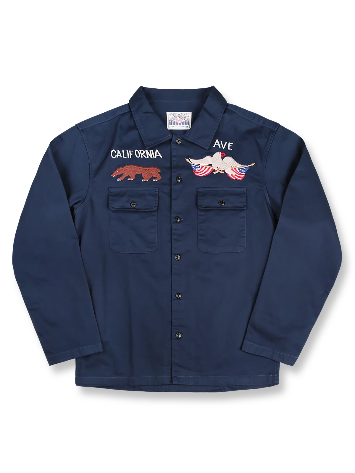 製品画像
厚手キャンバス生地で作られた刺繍キャンバスシャツの全体画像。1960年代のミリタリーユニフォームを再現したヴィンテージ感あるデザインが特徴。
詳細画像
フランス・ペリグーとアメリカ・カリフォルニア州をモチーフにした繊細な刺繍ディテールのクローズアップ。実用的なフラップ付きポケットも強調。