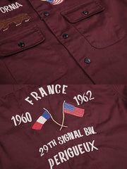 製品画像
厚手キャンバス生地で作られた刺繍キャンバスシャツの全体画像。1960年代のミリタリーユニフォームを再現したヴィンテージ感あるデザインが特徴。
詳細画像
フランス・ペリグーとアメリカ・カリフォルニア州をモチーフにした繊細な刺繍ディテールのクローズアップ。実用的なフラップ付きポケットも強調。